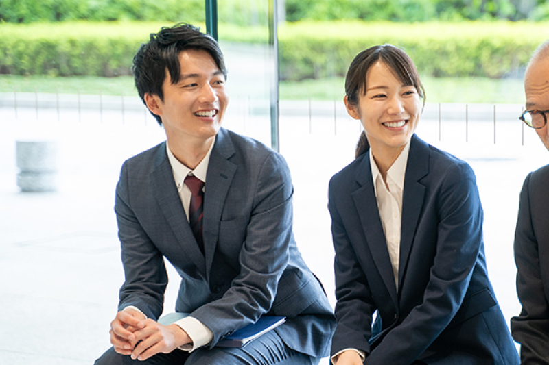 スーツ姿の笑顔の男女